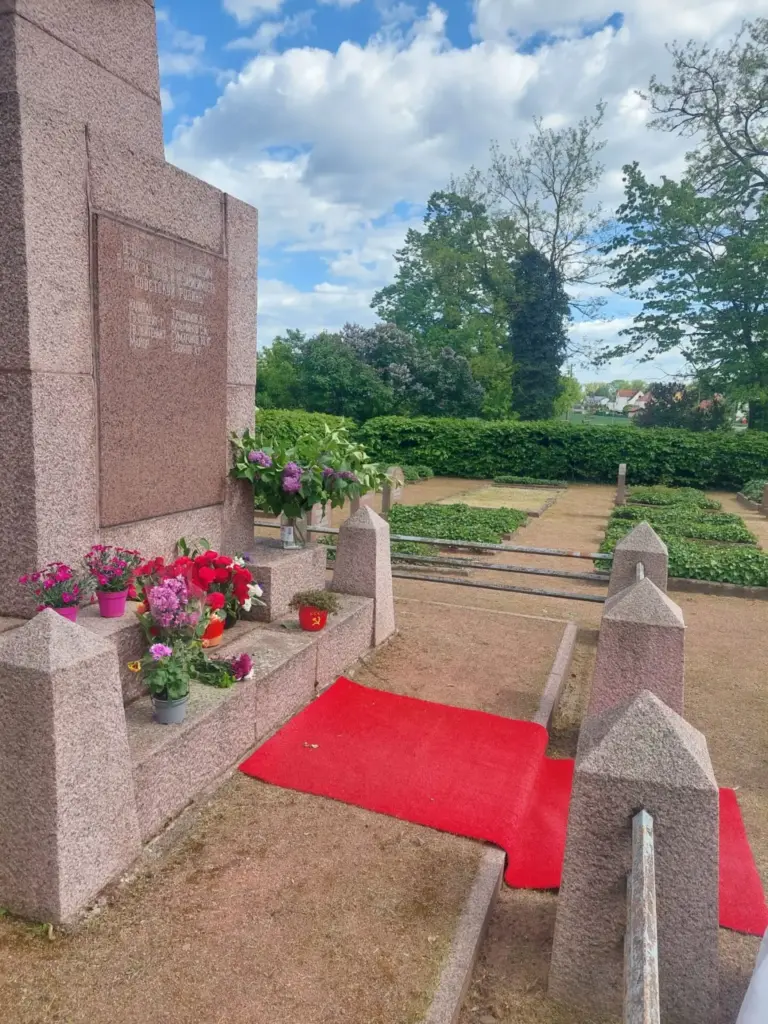 Tag der Befreiung vom Faschismus Sowjetisches Ehrenmal mit niedergelegten Blumen und rotem Teppich, daneben die Gräberreihen