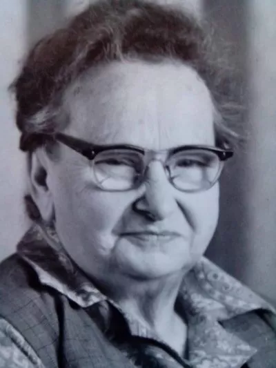 Schwarzweißporträt von Frieda Wilsdorf mit Brille und gemusterter Bluse