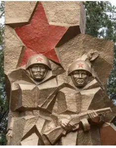 Relief an einem sowjetischen Ehrenmal: zwei Soldaten mit Helm vor einem roten Stern
